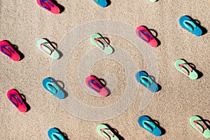 Pattern of beach colorful sandals or thongs on a sandy beach