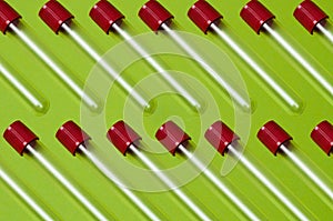 Pattern, blood collection tubes on a green background