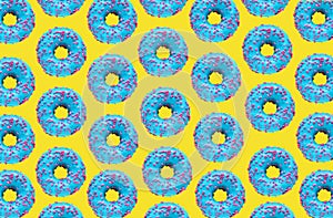 Pattern of a blue donut on a yellow background. Flat lay