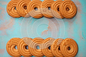 Pattern of butter cookies/biscuits on wooden teal green rustic background with space for text, flat lay design with butter cookies photo