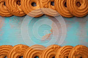 Pattern of butter cookies/biscuits on wooden teal green rustic background with space for text, flat lay design with butter cookies photo