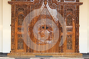 The pattern of carving wayang gunungan on the door of an Indonesian wooden house