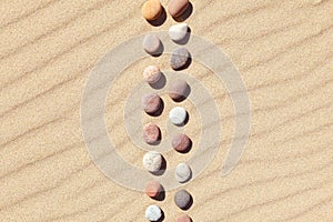 Pattern of colored pebbles on clean sand. Zen background, harmony and meditation concept photo