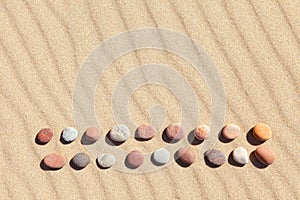 Pattern of colored pebbles on clean sand. Zen background, harmony and meditation concept