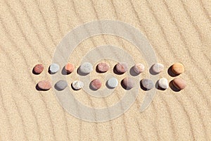 Pattern of colored pebbles on clean sand. Zen background, harmony and meditation concept