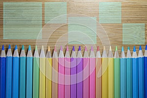 Pattern of colored pencils placed in a straight row with pencil tips on a close-up wooden table background, Colored pencils, Copy