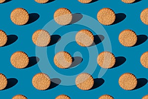 Pattern of cookies on a blue background. Minimal trendy sunlight concept