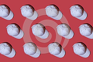 Pattern. Copy image of a white baseball cap on a red background.