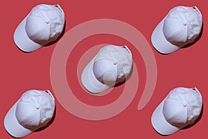 Pattern. Copy image of a white baseball cap on a red background.