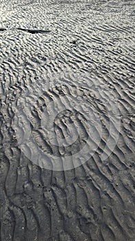 The pattern created on the beach sand that recedes due to the currents of the beach waves