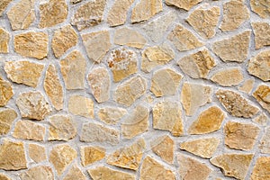 Pattern of decorative brown stone wall. Old castle wall background. Random size rock structure. Neatly stacked rough cut stone