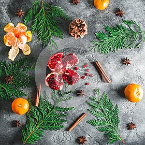 Pattern of delicious garnet, mandarin. cinnamon, anise and winter tree on dark background. Christmas concept. Flat lay. Top view