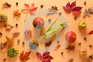 Pattern of fall harvest, pumpkins, apples, colorful autumn leaves on orange. Thanksgiving Day and Halloween. View from above