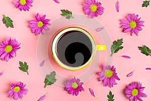 Pattern of flowers of pink asters, green leaves and yellow cup of hot coffee Americano on pink background Flat lay