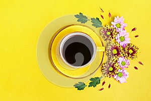 Pattern of flowers of red and white asters, green leaves and a cup of hot coffee Americano on yellow background