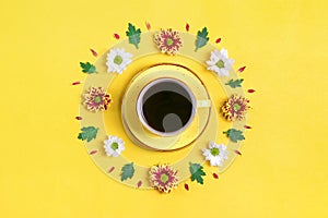 Pattern of flowers of red and white asters, green leaves and a cup of hot coffee on yellow background