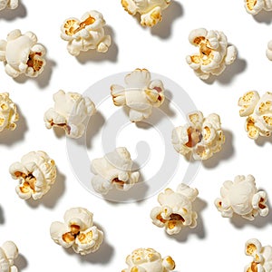 A pattern of freshly popped popcorn kernels on a white background