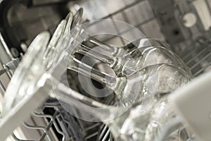 Pattern glasses of wine are stacked rhythmically in the dishwasher.