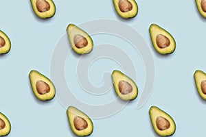 Pattern of half of avokado on blue background.