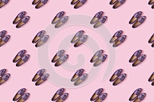 Pattern of lilac suede mocassin shoes over pink background