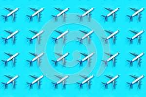 Pattern made of model airplane on blue background.