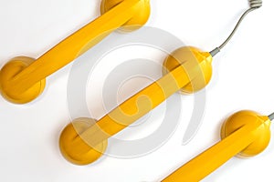 Pattern made from yellow color handset of a telephone on a white background.