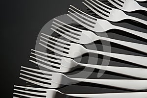 Pattern with many silver forks on black mirror background. Concept,