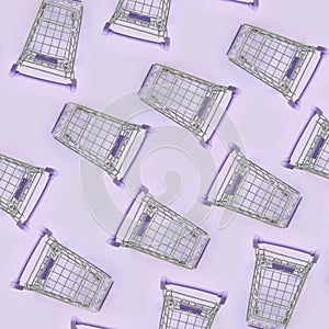 Pattern of many small shopping carts on a violet background. Minimalism flat lay top view