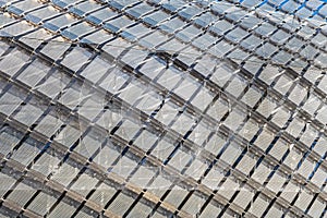 Pattern of metallic diamonds on modern building facade looks like a prison. Contemporary exterior shows a jail - like structure