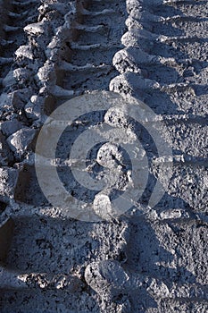 Pattern of a mining truck wheelprint on a wet dirt road