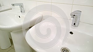 Pattern of modern bathroom sink and faucet in public toilet and restroom. Touchless taps. Virus protection concept. Sanitary rules