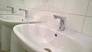 Pattern of modern bathroom sink and faucet in public toilet and restroom. Touchless taps. Virus protection concept. Sanitary rules