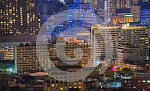 Pattern of office buildings windows illuminated at night. Lighting with Glass architecture facade design with reflection in urban