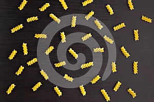 Pattern of A pile of pasta spiral fusilli on black background