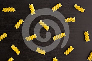 Pattern of A pile of pasta spiral fusilli on black background