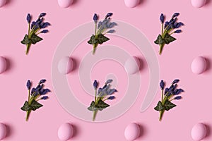 Pattern of pink Easter eggs and spring flovers over pink background