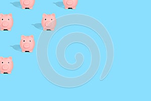 . Pattern of pink piggy banks on a blue background. Financial savings concept