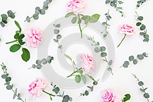 Pattern of pink roses flowers and eucalyptus on white background. Flat lay
