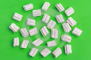 Pattern of pink sweet marshmallows on a green background.