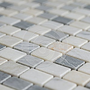 Pattern of rectangular marble tiles in shades of gray, white, and cream, arranged in a