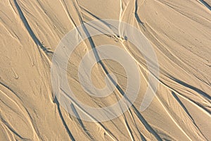 Pattern of sand after low tide at beach. Abstract Background.