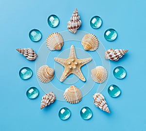 Pattern of seashells, starfish, and blue glass beads on a light blue background