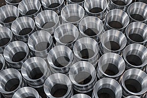 Pattern of shiny circular precision stainless steel industrial machine parts arranged in rows. Steel products to