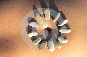 Pattern of small sea stones on women`s skin, pebble beach on a summer day