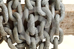 Pattern of thick rusty chain hang on wooden rail