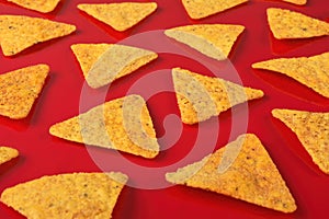 Pattern of Tortilla chips on a red background.
