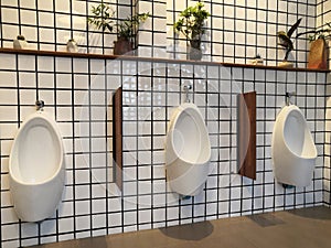 Pattern of urinals for men on background,ceramic urinals in a row in men public restroom. Urine infections.male toilet.