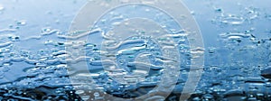 Pattern of water drops in a shiny metallic surface with table reflections