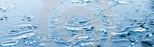 Pattern of water drops in a shiny metallic surface with table reflections