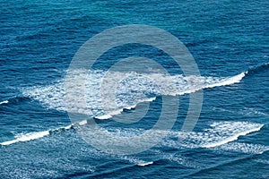 pattern of waves with spume at the beach